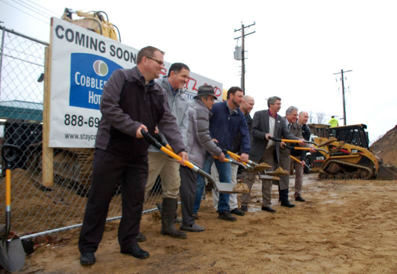 people breaking ground at the grounds of the cobblestone inn and suites