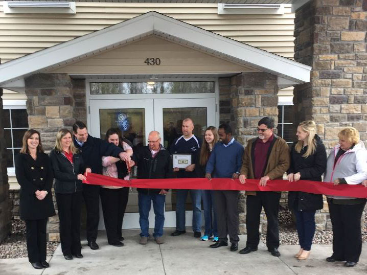 people cutting the ribbon at the cobblestone inn and suites