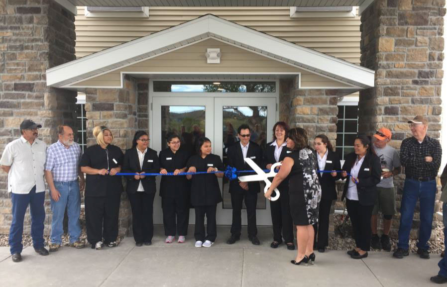 people cutting the ribbon at cobblestone inn and suites 