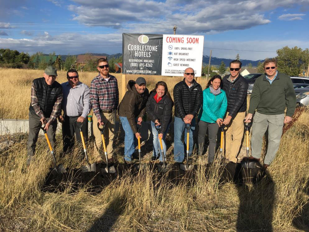 people with shovels at the ground breaking of the cobblestone hotel and suites 