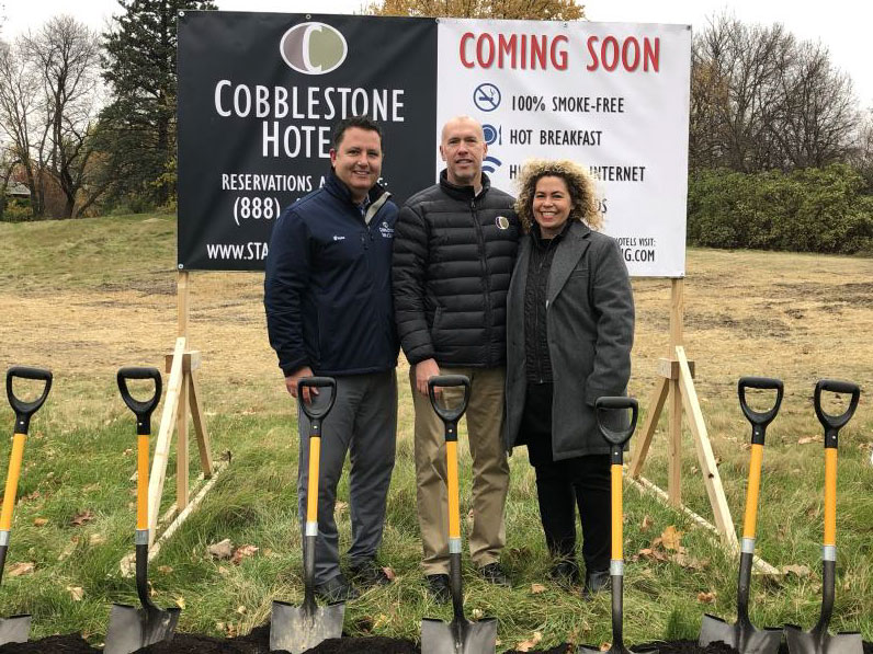 people with shovels at the grounds of the cobblestone hotel and suites 