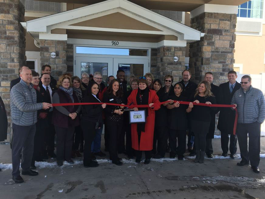 people at the ribbon cutting of the new cobblestone hotel and suites 