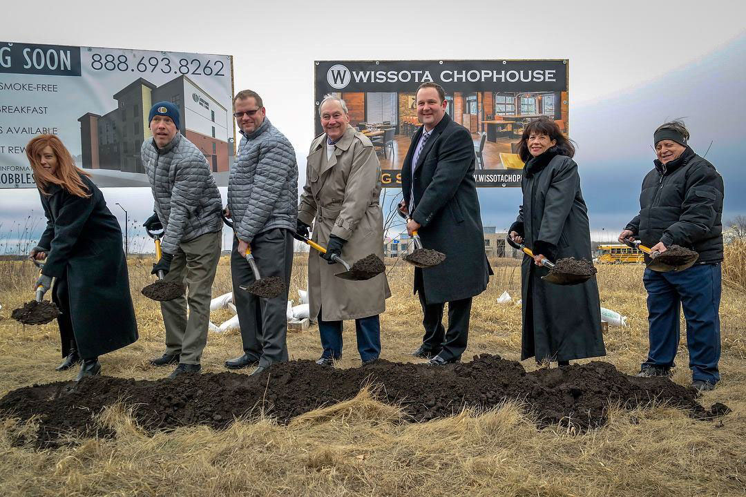 people with shovels at the ground breaking at their headquarters 