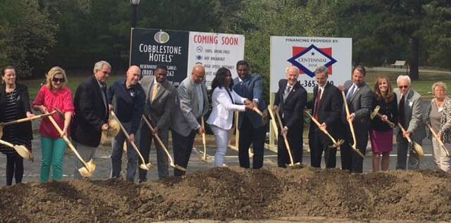people with shovels breaking ground on the cobblestone inn and suites 