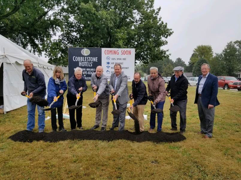 people with shovels breaking the ground at the new coblestone inn and suites 