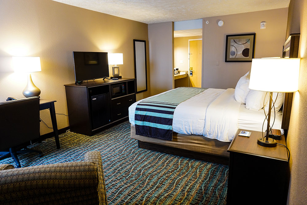 guest room with one king bed at a boarders inn and suites