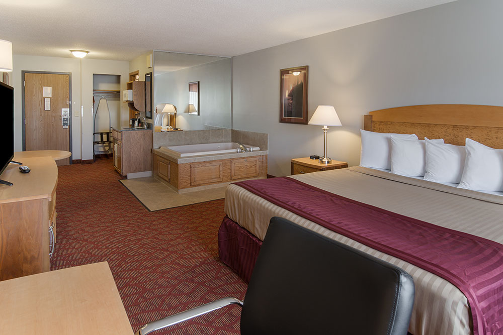whirlpool suite with king bed at a boarders inn and suites