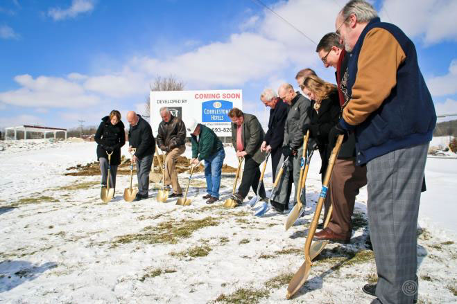 people with shovels breaking ground at the new cobblestone hotel and suites 