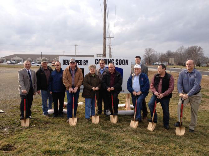 people with shovels at the ground breaking of the cobblestone hotel and suites