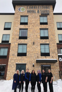 A group of people standing in front of a building

Description automatically generated with medium confidence